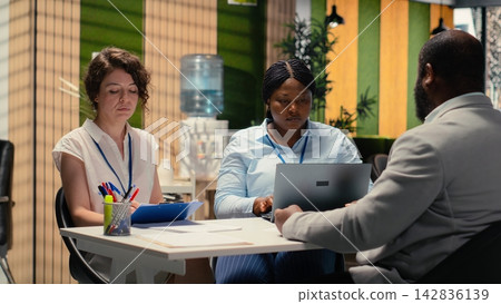 Diverse recruiters evaluating an applicant CV resume during interview session focused on selecting candidates with relevant qualifications and strong career ambition. Head hunting. Diverse recruiters evaluating an applicant CV resume during interview session focused on selecting candidates with relevant qualifications and strong career ambition. Head hunting. 142836139