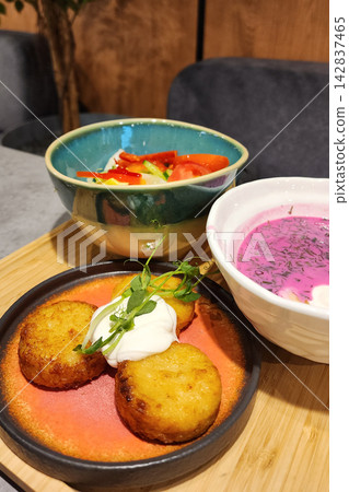 Draniki potato pancakes with sour cream, cold beet soup and salad Draniki potato pancakes with sour cream, cold beet soup and salad 142837465