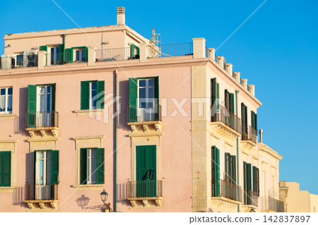 The architectural exterior features classic balconies and traditional window treatments on a historic residential structure in Mediterranean style The architectural exterior features classic balconies and traditional window treatments on a historic residential structure in Mediterranean style 142837897