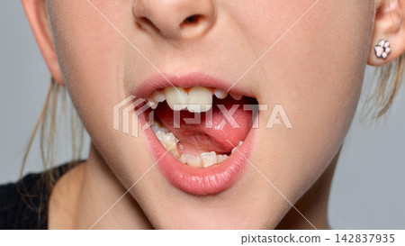 Playful child sticks out her tongue in neutral studio closeup with mischievous joy Playful child sticks out her tongue in neutral studio closeup with mischievous joy 142837935