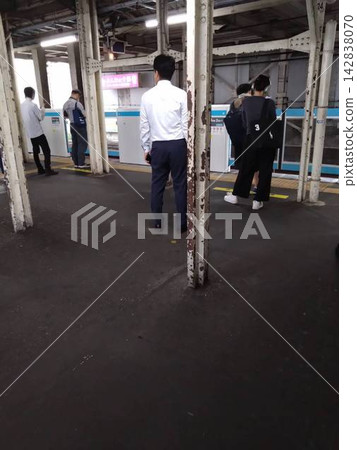 這是典型的清晨通勤者在月台上等候火車的場景。 這是典型的清晨通勤者在月台上等候火車的場景。 142838070