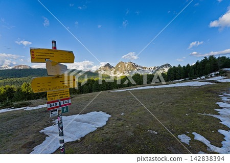 Yellow trail marker on snowy mountain path in Prokletije National Park Yellow trail marker on snowy mountain path in Prokletije National Park 142838394