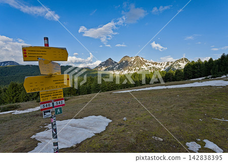Yellow trail marker on snowy mountain path in Prokletije National Park Yellow trail marker on snowy mountain path in Prokletije National Park 142838395