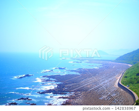 A panoramic view of the beautiful coastline with its clear blue sea and endless stretches of wave-shaped rock formations. A panoramic view of the beautiful coastline with its clear blue sea and endless stretches of wave-shaped rock formations. 142838967