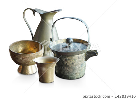 side view antique and old brass kettle, brass pitcher, brass glass, brass cup, on white background, decor, kitchen, fashion, collection, ancient, copy space side view antique and old brass kettle, brass pitcher, brass glass, brass cup, on white background, decor, kitchen, fashion, collection, ancient, copy space 142839410