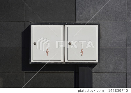 Double electrical utility box on a dark grey tiled wall Double electrical utility box on a dark grey tiled wall 142839740