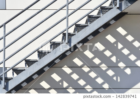 Metal external staircase with geometric shadows Metal external staircase with geometric shadows 142839741