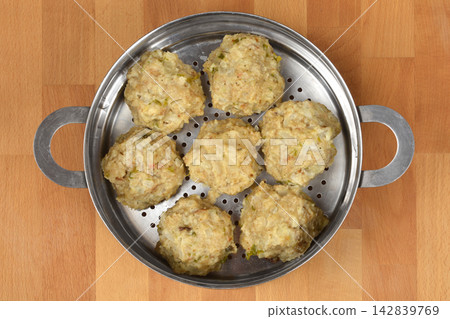 Top view of seven bread dumplings in a metal steamer 142839769