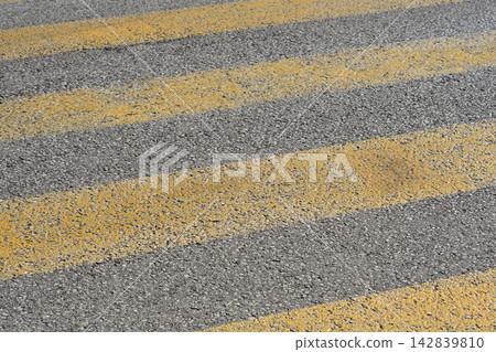Yellow pedestrian crossing lines on asphalt Yellow pedestrian crossing lines on asphalt 142839810