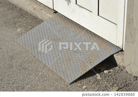 Metal checker plate ramp at a building entrance Metal checker plate ramp at a building entrance 142839880