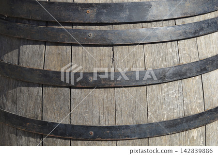 Old wooden oak barrel texture with metal hoops Old wooden oak barrel texture with metal hoops 142839886