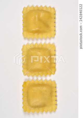 Three raw ravioli pasta arranged vertically on white background Three raw ravioli pasta arranged vertically on white background 142840122