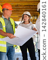 Workers discuss blueprint and share technical observations 142840161