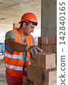 Specialist stacks bricks in area during work process 142840165