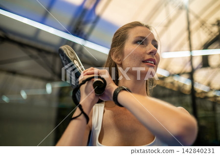 Young woman with a paddle tennis racket in hands Young woman with a paddle tennis racket in hands 142840231