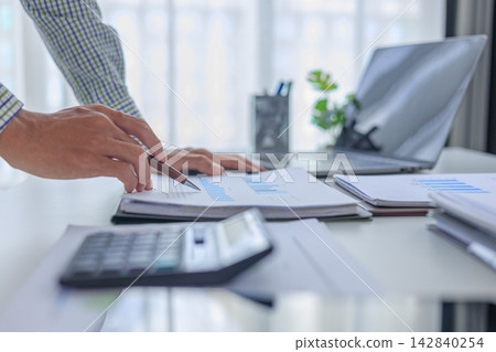 Professional financial advisor auditing company profit graph statistics paper report at desk in modern office. 142840254