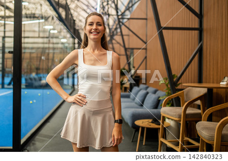 Long-haired blonde woman in tennis skirt ate the paddle tennis courts Long-haired blonde woman in tennis skirt ate the paddle tennis courts 142840323