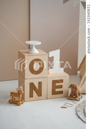 Wooden ONE letter cubes with cake stand and toys for first birthday photo shoot Wooden ONE letter cubes with cake stand and toys for first birthday photo shoot 142840651