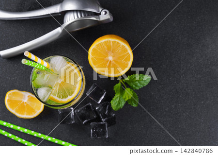 Refreshing homemade lemonade with lemon slices, fresh mint, ice and citrus juicer, cold beverage Refreshing homemade lemonade with lemon slices, fresh mint, ice and citrus juicer, cold beverage 142840786