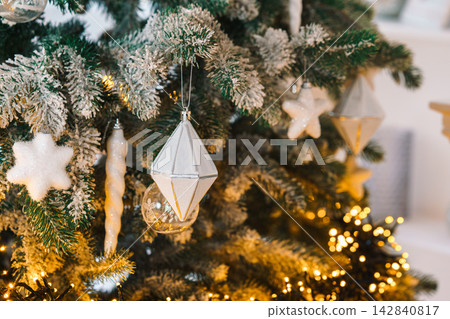 Christmas tree branch decorated with white ornaments, star, icicles and glowing lights, holiday mood Christmas tree branch decorated with white ornaments, star, icicles and glowing lights, holiday mood 142840817