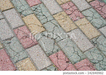 Cracked and Damaged Colorful Concrete Paving Stones Showing Surface Deterioration and Wear Cracked and Damaged Colorful Concrete Paving Stones Showing Surface Deterioration and Wear 142840982