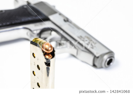 bullet .380 APC or 9mm Kurz FMJ (Full Metal Jacketed) in magazines and PPKs gun in background. bullet .380 APC or 9mm Kurz FMJ (Full Metal Jacketed) in magazines and PPKs gun in background. 142841068