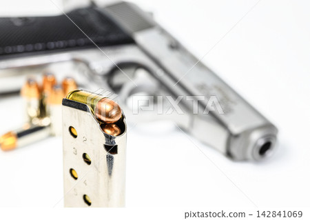 bullet .380 APC or 9mm Kurz FMJ (Full Metal Jacketed) in magazines and PPKs gun in background. bullet .380 APC or 9mm Kurz FMJ (Full Metal Jacketed) in magazines and PPKs gun in background. 142841069