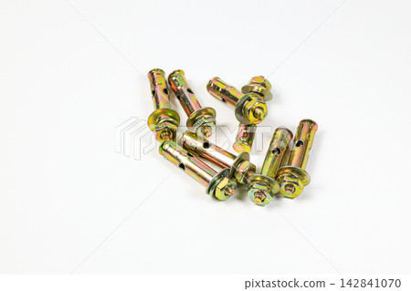 Golden sleeve anchor bolts or Expansion Bolt or Expansion Anchor for concrete wall mounting lying on white background. 142841070