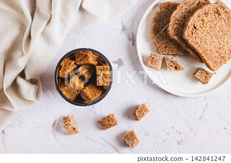 Fermented bread-based drink (kvass) in a glass on the table top view Fermented bread-based drink (kvass) in a glass on the table top view 142841247