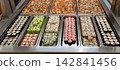 Sushi roll japanese food in grocery store, buffet, or food court. Buying sushi rolls in a store. Japanese food. Various types of sushi rolls on display at a grocery store. 142841456