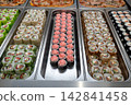 Sushi roll japanese food in grocery store, buffet, or food court. Buying sushi rolls in a store. Japanese food. Various types of sushi rolls on display at a grocery store. 142841458
