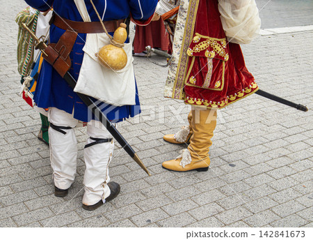 Participants show traditional costumes during Moros y Cristianos festival in Spain with boots and swords 142841673