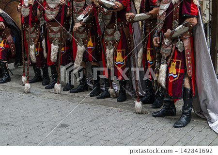 Participants in red and brown medieval warrior costumes stand in line during Moors and Christians festival in Spain Participants in red and brown medieval warrior costumes stand in line during Moors and Christians festival in Spain 142841692