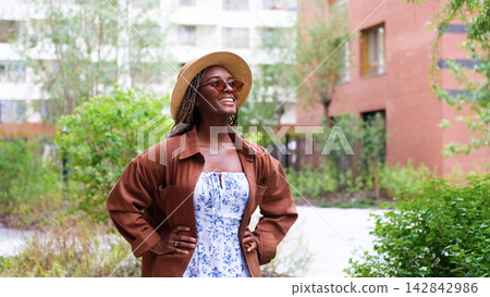 Young woman resting and relaxing while walking on city street in new eco-friendly residential complex. Relaxation and stress-free concept. Young woman resting and relaxing while walking on city street in new eco-friendly residential complex. Relaxation and stress-free concept. 142842986