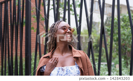 Young woman resting and relaxing while walking on city street in new eco-friendly residential complex. Relaxation and stress-free concept. Young woman resting and relaxing while walking on city street in new eco-friendly residential complex. Relaxation and stress-free concept. 142843203