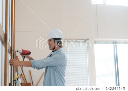 A man installing lumber. A man installing lumber. 142844545