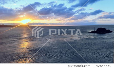 黎明時的大海和冉冉升起的太陽穿透雲層(日出的光芒和一座小島) 黎明時的大海和冉冉升起的太陽穿透雲層(日出的光芒和一座小島) 142844630