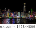香港維多利亞港的摩天大樓在夜色中熠熠生輝，倒映在水面上。 142844809