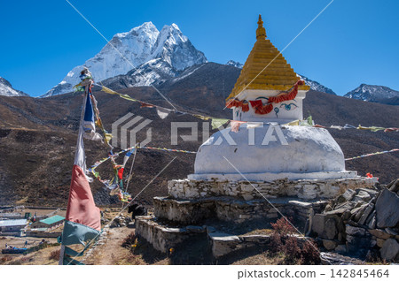 An old Tibetan Buddhist stupa with beautiful view of Mt.Ama Dablam seen from Dingboche village in Nepal. An old Tibetan Buddhist stupa with beautiful view of Mt.Ama Dablam seen from Dingboche village in Nepal. 142845464