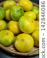 Autumn delicacies: Early-ripening mandarins served in a basket 142846086