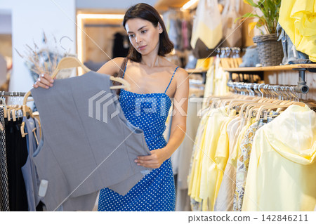 Adult woman choosing vest in clothing store Adult woman choosing vest in clothing store 142846211