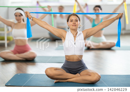 Group of young women doing pilates with band Group of young women doing pilates with band 142846229