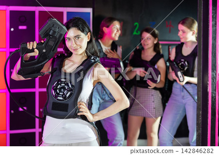 Portrait of happy cheerful girl with laser gun for playing laser tag Portrait of happy cheerful girl with laser gun for playing laser tag 142846282