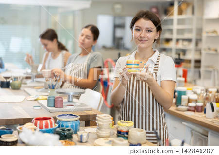 Young girl with handmade ceramic cup in workshop Young girl with handmade ceramic cup in workshop 142846287