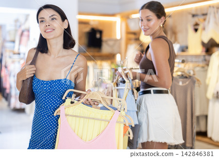 Two women standing in a boutique and choosing clothes 142846381
