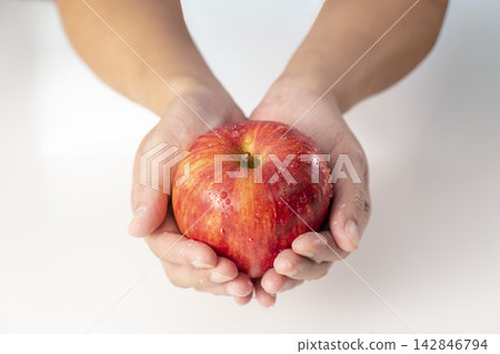 Image of a man holding a Sun Tsugaru apple (front view) Image of a man holding a Sun Tsugaru apple (front view) 142846794
