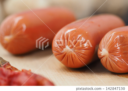 Preparation of fresh sausages on a wooden table next to spices 142847130