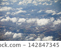 Aerial view of the cityscape and coastline unfolding through gaps in the clouds. 142847345
