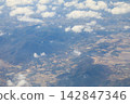 Aerial panoramic view of mountain ranges and valleys stretching out under a blue sky. 142847346