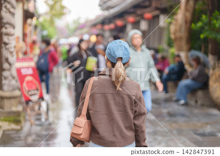 Happy woman traveler travel in Chengdu city. Tourist sightseeing and shopping in Kuan Zhai Alley or wide and narrow alleys, Famous Landmark for tourism attraction in Sichuan, China Happy woman traveler travel in Chengdu city. Tourist sightseeing and shopping in Kuan Zhai Alley or wide and narrow alleys, Famous Landmark for tourism attraction in Sichuan, China 142847391